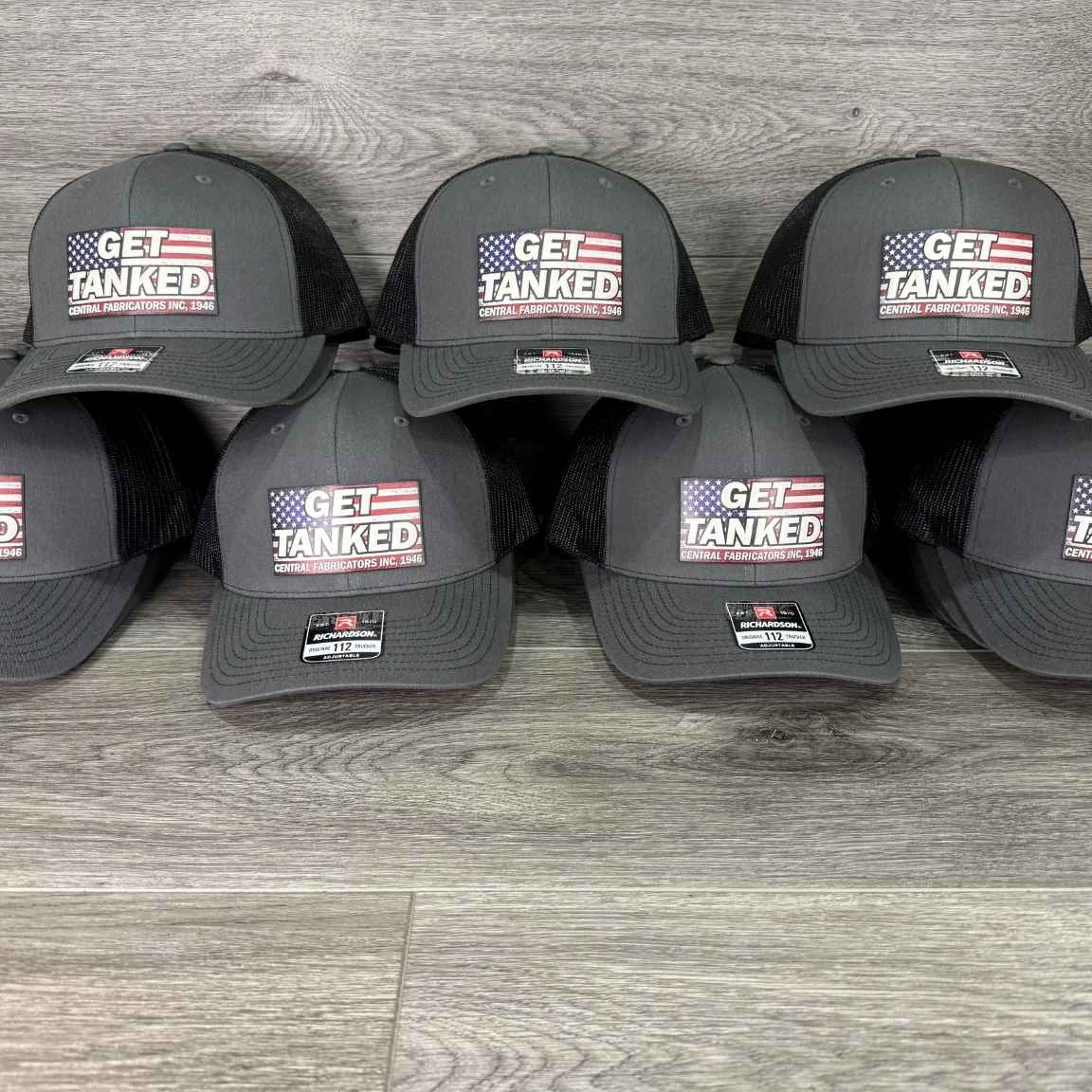 Rows of charcoal and black Richardson 112 trucker hats with a full color American flag logo patch for a bulk order
